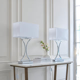 Endon Brackton twin pack table lamps in chrome with curved metal bases and white rectangular fabric shades, styled on a marble console table.