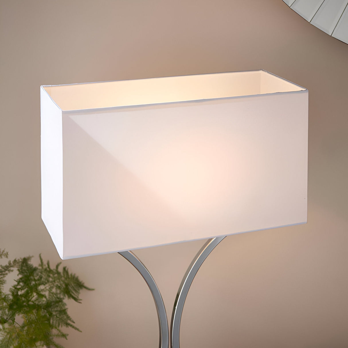 Endon Brackton table lamp with white rectangular cotton-mix shade on a curved chrome base, illuminated against a neutral wall.