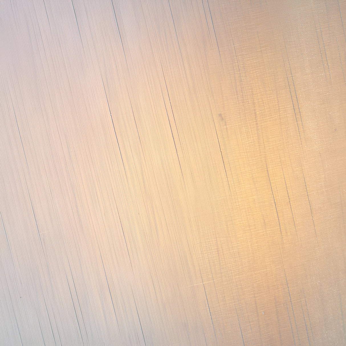 Close-up of a textured metallic surface in warm gold and neutral tones, showing fine linear detailing on the Brockstead Table Lamp Twin Pack - Gold.