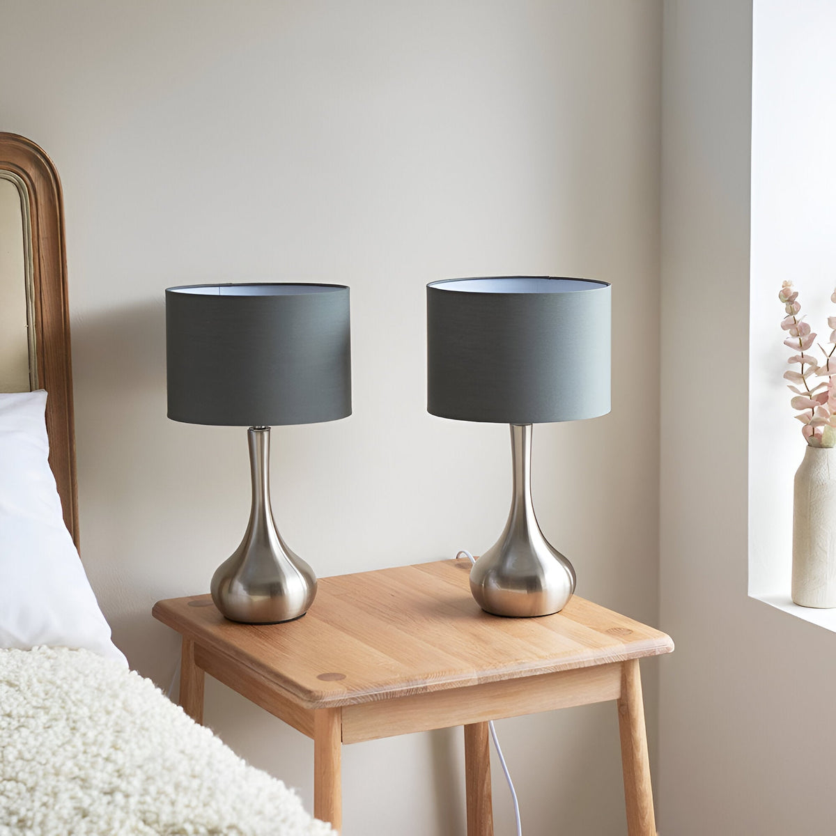 Endon Chartbury LED table lamps in a twin pack, with satin nickel teardrop bases and grey drum shades, shown on an oak bedside table.