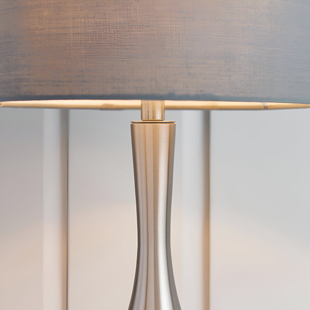 Close-up of the Endon Chartbury LED table lamp's slim satin nickel base and grey fabric drum shade.