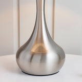 Close-up of the Endon Chartbury table lamp's satin nickel teardrop-shaped metal base resting on a white surface against a pale neutral background.