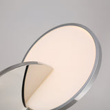 The Half Moon LED Pendant Light - Silver features a modern, circular design with a sleek metallic frame and illuminated surface, accented by a partially obscured reflective panel, set against a plain light gray background.