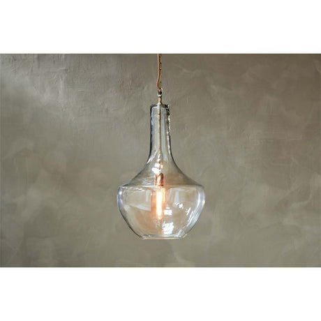 Agatarla Large Recycled Glass Pendant Light in Clear, a flask-shaped glass shade with brass chain and ceiling plate, hanging against a plain grey wall.
