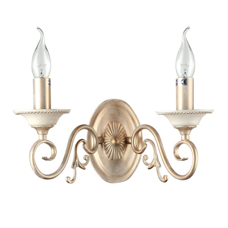 The Perla 2 Light Classic Wall Light features a vintage-inspired design with two candle-shaped bulbs on gracefully curved arms and a decorative backplate, all in a soft gold finish.