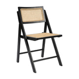 Ashton folding dining chair with black matt ash wood frame and natural cane back and seat, shown at an angle on a plain white background.
