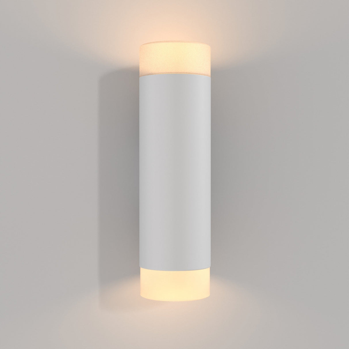 The Kilt LED Up & Down Wall Light 10W 3000K - White features a modern cylindrical design emitting a soft, warm glow from both ends. Elegantly mounted on a light gray wall, it provides energy-efficient illumination for a cozy ambiance.