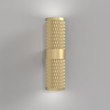 The Focus Design Up & Down Wall Light in matte gold, with a textured diamond pattern and a central band, emits soft light from both ends. It adds contemporary elegance as it mounts on a plain light gray wall.