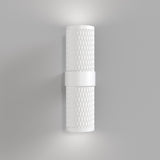 The Focus Design Up & Down Wall Light - White is a modern, cylindrical wall light with a textured pattern. Mounted vertically on a light gray wall, it provides soft illumination from both the top and bottom.