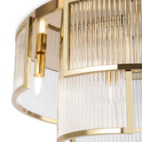 Close-up of the Frame 6 Light Flush - Gold, highlighting an elegant chandelier with a gleaming frame and clear glass rods. Two visible bulbs cast a warm glow, reflecting off the polished metal and embodying modern lighting elegance.