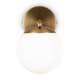 The Marble Wall Light combines a brushed brass backplate with a white opal glass spherical shade, blending simple geometry and luxurious finishes for an elegant, contemporary appearance.