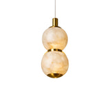 The Lumina 2 Light Orb Alabaster Single Pendant Light features stacked spherical alabaster shades in soft white with brass accents, suspended from a thin white cord against a white background.