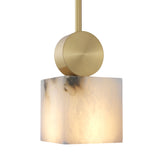 The Serano 1 Light Medium Vertical Pillar Pendant features a glowing, cube-shaped Spanish alabaster shade with soft white and gray marbling, paired with a modern brass fixture.