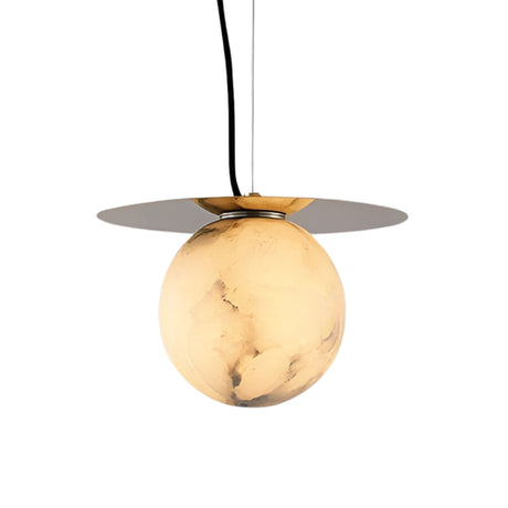 The Marenzo 1 Light Small Orb Alabaster Single Pendant Light in Soft White & Brushed Brass features a round, marble-patterned globe and a flat brass disc above, suspended by a black cord against a white background.