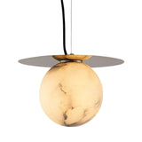 The Marenzo 1 Light Large Orb Alabaster Pendant in soft white and brushed brass features a marble-patterned globe emitting a warm glow, suspended beneath a flat brass disc with a black cord.