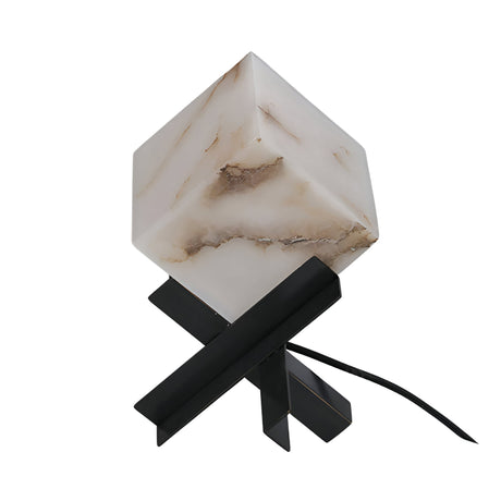 The Kalythra 1 Light Faceted Alabaster Table Lamp features a marble-textured, cube-shaped shade and intersecting matte black base. This sculptural piece includes a power cord extending from the base.