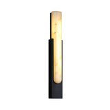The Nerava LED Large Segmented Alabaster Wall Light in soft white and black features a vertical frosted glass shade on a sleek black base, casting a warm glow—ideal for stylish, modern interiors.
