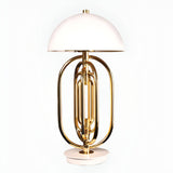 The Ascot 4 Light Large Table Lamp in white and gold features a modern Art Deco design with a dome-shaped white shade, a gold-finished metal base inspired by a tuba, and stands on a round white platform.