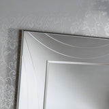 A detailed view of the Lumis Rectangle Wall Mirror Silver - 108x77cm, showcasing its stylish silver frame that exudes modern elegance as it reflects a subtly patterned wall with a floral motif.