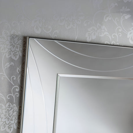 A detailed view of the Lumis Rectangle Wall Mirror Silver - 108x77cm, showcasing its stylish silver frame that exudes modern elegance as it reflects a subtly patterned wall with a floral motif.
