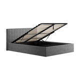 Berlin Ottoman double bed frame in silver velvet, shown open with gas-lift mechanism revealing slatted storage base and channel-tufted headboard on a plain white background.