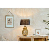 Baba Large Tall Recycled Glass Lamp Base in green with a black fabric shade, styled on a wooden sideboard beside framed art and a plant.
