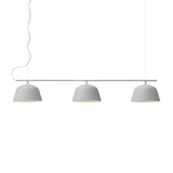 Niori Bounds 3 Light Linear Pendant in light grey with three matt dome shades on a slim horizontal bar suspended by thin cables, on a white background.