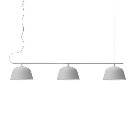 The Bounds 3 Light Linear Suspension Light in light grey features three evenly spaced dome-shaped white lampshades hanging from a horizontal bar by two cords, with a minimalist design against a plain white background.