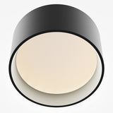 The Vega LED Round Surface Downlight 12W 3000K - Black is displayed against a white background, showcasing its modern black circular design with a textured off-white diffuser. This stylish fixture features an LED downlight for vibrant illumination, ideal for contemporary interiors.