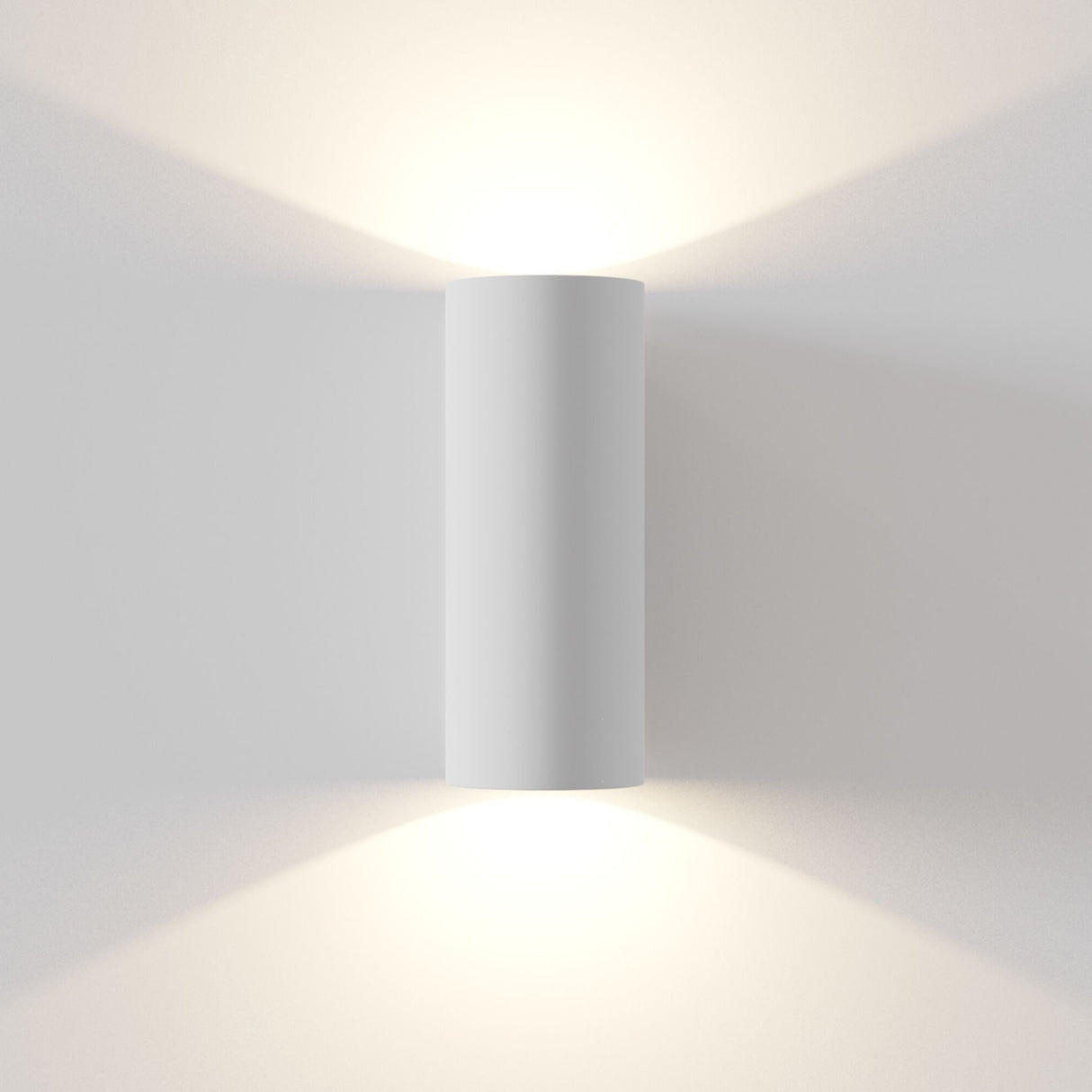 Parma paintable white cylindrical wall light installed, highlighting its up and down lighting capability and customisable finish for any decor.