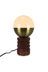 The Velar 1 Light Sculpted Marble Table Lamp in brass and dark terracotta red features a round, half-gold, half-white glass shade on a textured cylindrical base with a black power cord, set against a plain white background.
