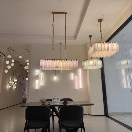 Lunaro 20 Light Tiered Alabaster Chandelier in Brushed Brass, square stepped design shown suspended above a dining table in a modern showroom setting.