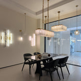 Lunaro Linear Panel Alabaster Chandelier in brushed brass with carved alabaster panels, shown suspended above a dining table in a modern interior.