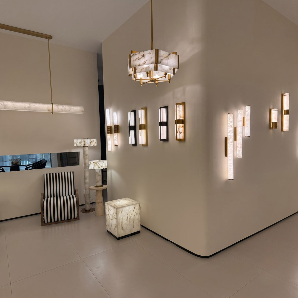 Quadrena Drum Alabaster Chandelier 60cm in brushed brass, faceted two-tier panels, hung in a showroom alongside matching wall lights and alabaster furniture.