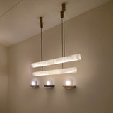 Zareon LED Large Linear Alabaster Chandelier featuring two alabaster cylindrical tubes on twin cables from wooden ceiling mounts, glowing warm white in a neutral-toned room.