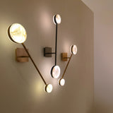 Marvello LED Twin Sphere Alabaster Wall Light in matt black, shown installed alongside similar brass wall lights with round alabaster discs on a neutral wall.