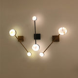 Marvello LED Twin Sphere Alabaster Wall Light in brushed brass, shown with matching multi-arm sconces featuring glowing alabaster discs on a neutral wall.