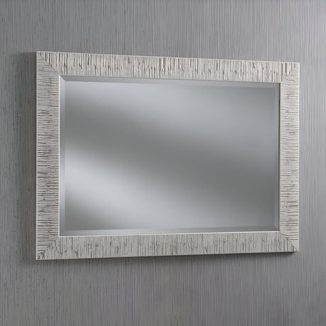 The Radix Rectangle Wall Mirror - White/Silver features a textured, light frame that exudes modern luxury. When hung against a vertically striped gray wall, it reflects a blurred, neutral background and adds a contemporary look to any room.