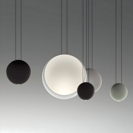 Five Cosmos LED Large Pendant Lights of different sizes and shades hang from the ceiling against a neutral background, creating a modern minimalist lighting arrangement with soft ambient light.