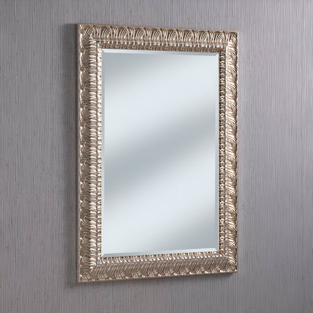 The Crown Rectangle Wall Mirror - Silver features an ornate rectangular design with a stunning silver frame, beautifully displayed against a light gray textured wall. The intricate carvings and modern elements combine timeless elegance with versatile charm.