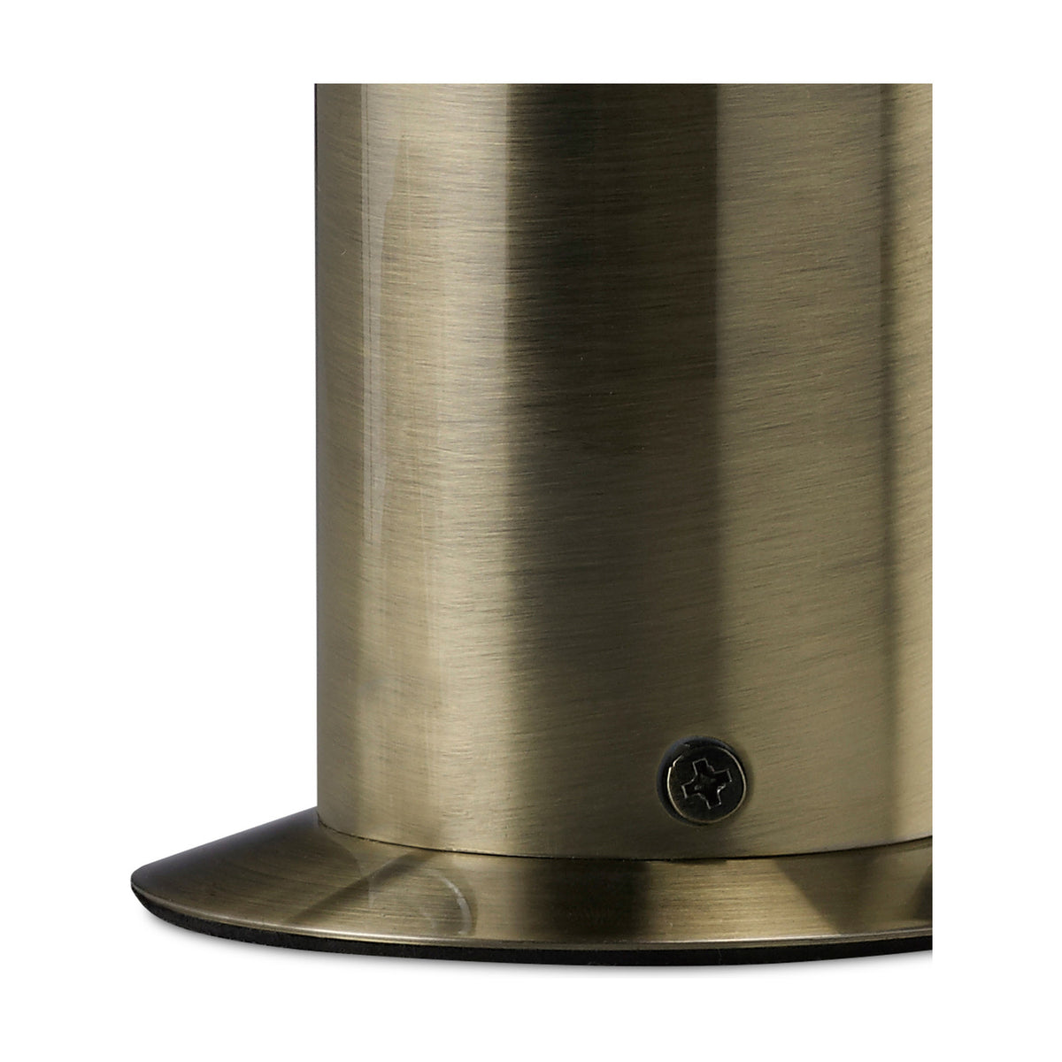Close-up of the Indio GU10 Table Lamp base in antique brass, showing the cylindrical iron column, oval foot plate and visible fixing screw on a plain background.