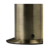 Close-up of the Indio GU10 Table Lamp base in antique brass, showing the cylindrical iron column, oval foot plate and visible fixing screw on a plain background.