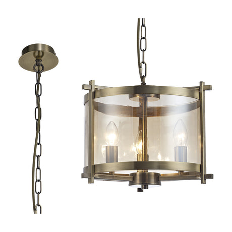 Nolan 3 Light E14 Pendant Light, 36cm drum-style antique brass frame with amber glass panels and three exposed candle bulbs, shown with matching chain and ceiling rose on a white background.