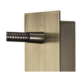 Close-up of the Winslow Oval Wall Light in antique brass, showing the flexible ribbed metal arm and cylindrical joint connecting to the rectangular brass wall plate.