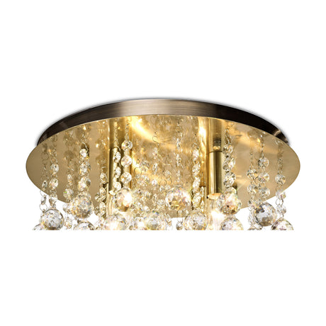 Acton 4 Light E14 round flush ceiling light in antique brass, 38cm frame with clustered clear crystal spheres, shown lit against a plain white background.
