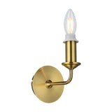 Banyan E14 wall light in antique brass, single-arm design with round backplate, exposed candle bulb, iron construction, shown on a plain white background.
