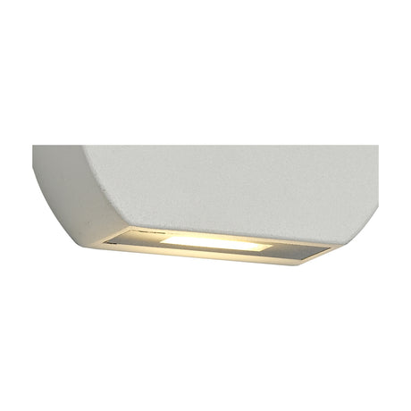 Lucina 99mm outdoor wall light in sand white aluminium with clear shade, angled view showing warm LED glow, IP54 rated, on a plain white background.