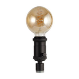 Kork E27 Table Lamp 60mm in black iron, a bottle-neck lamp holder with rotary switch, shown fitted with a large amber globe bulb on a plain white background.