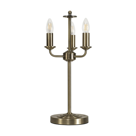 Banyan 3 Light E14 Table Lamp in antique brass finish, with three curved arms rising from a central stem to candle-style lampholders on a round base, shown against a plain white background.