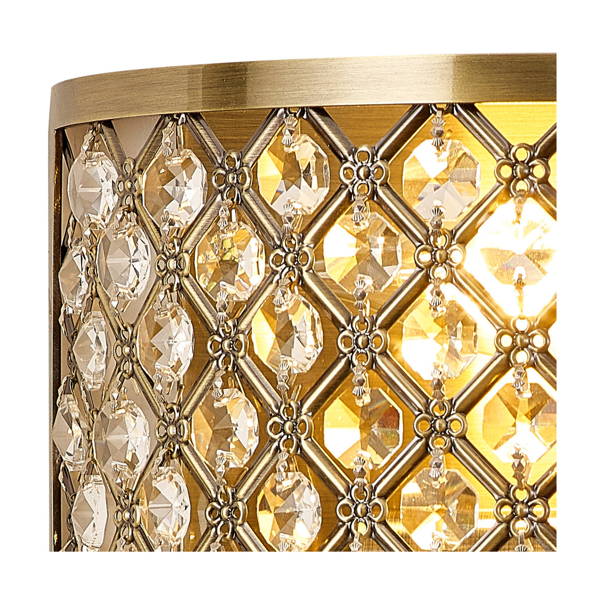 Close-up of the Sasha 2 Light E14 Wall Light in antique brass, showing a diamond-patterned trellis of clear faceted crystals over a warm illuminated glass shade.